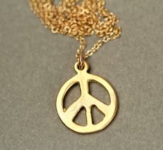 Gold peace sign necklace - peace necklace - delicate and dainty - a 14k gold plated little gold peace symbol on a 14k gold filled chain A cute little 14k gold overlay peace sign hangs from a 16 inch 14k gold filled chain. Please feel free to select a different length chain if you prefer! Also available in sterling silver! The peace sign measures 12mm. Looking for other charm necklaces? https://www.etsy.com/shop/BubuRuby?section_id=12318467 More from Bubu Ruby? https://www.etsy.com/shop/BubuRuby? Gold Jewelry With Peace Sign For Gift, Cheap Adjustable Jewelry With Peace Sign, Spiritual Peace Sign Necklace As A Gift, Gold Peace Sign Jewelry Gift, Adjustable Peace Sign Necklace, Peace Sign Necklace Hippie, Peace Necklace, Peace Sign Necklace, Peace Sign