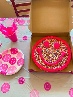 a birthday cake in a box with sprinkles on the table next to it