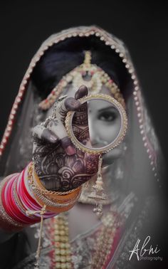 a woman with henna on her hand holding a mirror in front of her face