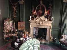 a living room filled with furniture and a fire place covered in candles next to a painting