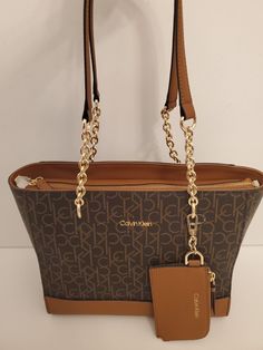 Calvin Klein Tote Handbag And Bonus Card Case CK Logo Brown with gold hardwear. Original price: $198.00 Removable coin pouch 100% man made material Dimensions: 11" ×  9.5" × 5.5" Ck Logo, Tote Handbag, Medium Tote, Coin Pouch, Card Case, Brown Gold, Tote Handbags, Bags Handbags, Calvin Klein