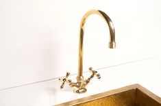 a gold sink and faucet in a bathroom