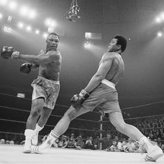 two men are in the middle of a boxing match, one is about to punch the other