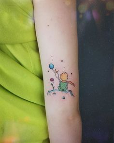 a person with a small tattoo on their arm holding a blue balloon in the air