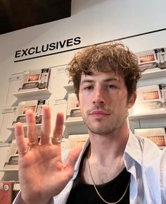 a young man making the vulcan sign with his hand in front of a store display