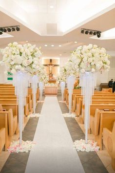 the aisle is decorated with white flowers and ribbons