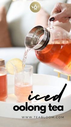 a person pouring tea into a glass pitcher