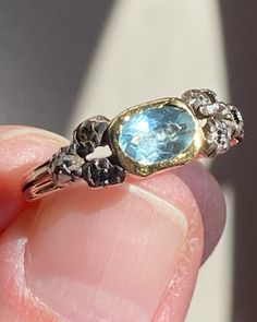 The soft, oceanic hues of this antique aquamarine ring transport one back to the Regency era of Jane Austen.  The luscious blue turquoise color softens and heightens depending on the intensity of the lighting, but the underlying foiling gives a soft glow from within in every type.  Likely English in origin, though mimicking a French design. Size 6. A very rare collector's piece! Luxury Blue Topaz Rings With Rose Cut Diamonds, Luxury Blue Topaz Ring With Rose Cut Diamonds, Blue Topaz Ring With Rose Cut Diamonds For Anniversary, Anniversary Blue Topaz Ring With Rose Cut Diamonds, Heirloom Blue Sapphire Ring With Rose Cut Diamonds, Blue Rings With Rose Cut Diamonds For Promise, Blue Rose Cut Diamond Promise Ring, Antique Blue Multi-stone Jewelry, Luxury Turquoise Aquamarine Rings