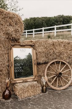 an old wagon with hay and a mirror