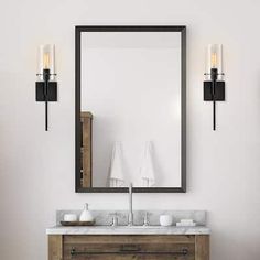 a bathroom vanity with two lights and a mirror