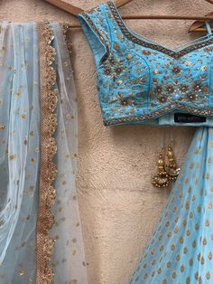 A three-piece powder blue sharmily zari lehenga set from the Priti Sahni collection. This georgette powder blue butti lehenga with pearl-zari work border detail is paired with a powder blue blouse in raw silk fabric with sequin and zardozi hand embroidery. This outfit is completed with a powder blue tulle dupatta in net material with sequin work. Zari Lehenga, Designer Lehnga Choli, Math Shirts, Raw Silk Fabric, Blue Tulle, Zari Work, Raw Silk, Blue Blouse, Three Piece