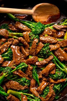 beef and broccoli stir fry in a skillet with a wooden spatula