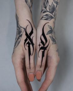 two hands that have tattoos on them