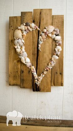 an image of a heart made out of seashells on a piece of wood