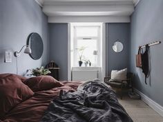 a bed sitting in a bedroom under a window next to a radiator and lamp