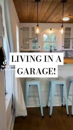 a kitchen with white cabinets and stools next to a counter top that says living in a garage