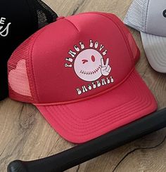 Keep it groovy in this Peace, Love and Basketball Trucker hat. Bright red is sure to make you stand out, whether you're at the game or at the beach. No Retuns on Hats Tag us on Instagram: @rowdiethreads Baseball Trucker hat  | Peace Love Baseball | Trucker hat | Peace hat | Baseball Mom Fun Red Trucker Hat, Red Trucker Hat For Beach, Fun Snapback Hat With Short Brim For Beach, Red Trucker Hat For The Beach, Casual Red Trucker Hat For Beach, Fun Red Trucker Hat With Letter Print, Novelty Red Baseball Cap, Fun Red Trucker Hat For Beach, Beach Baseball Season Snapback Hat