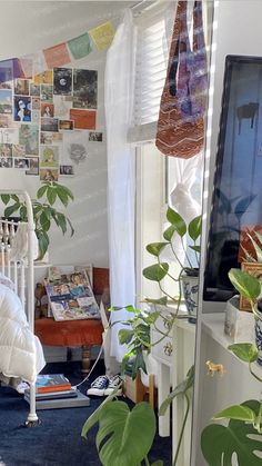 a bedroom with plants and pictures on the wall