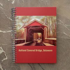 a red spiral notebook with the words ashland covered bridge, delaware written on it