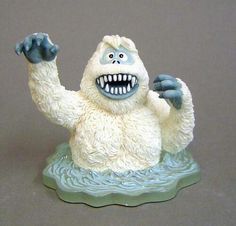 a figurine of a white monster with his arms in the air and mouth wide open