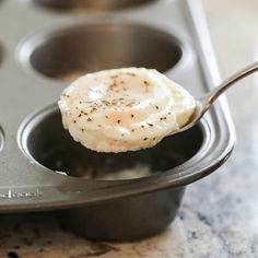 an egg in a muffin tin with a spoon