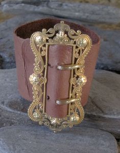 "This Victorian gold filled buckle has been sitting on my desk for 8 years. It is elegantly designed with a scroll and floral motif. I have wanted to make this into a bracelet but just couldn't find the time. I finally experimented with the leather. I chose a very supple leather that will probably darken from wearing and the oils in your skin giving it natural marks. For my first leather bracelet, I am happy with how it came out. The holes are not perfectly aligned but they look pretty good. Wha Leather Cuff Bracelet, Buckle Bracelet, Victorian Gold, Bracelet Leather, My Desk, Leather Cuffs Bracelet, Leather Cuffs, Bracelet Gold, Floral Motif