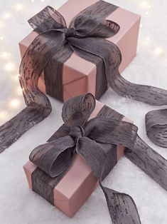 two wrapped presents sitting on top of snow covered ground