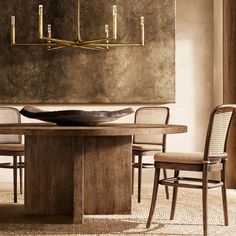 a dining room table with chairs and a large painting on the wall in the background