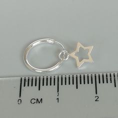 A PAIR of sterling silver hoops. Comes with a detachable tiny and delicate star charm. The charm is multipurpose and can be used with a neck or bracelet chain too. Dimension: Hoop- 12 x 1.2 mm Charm- 6 x 6 mm Weight: 0.97 gm Price listed is for a PAIR of hoops. These earrings are made of 925 hypoallergenic sterling silver and comes with a 925 stamp. Can be packaged in a gift box. I can include a personal message from you if needed You are welcome to contact me at... bhavnakwintra1956@gmail.com F Silver Star Earrings With Charms, Silver Dangle Hoop Earrings With Star Charm, Minimalist Silver Star Hoop Earrings, Sterling Silver Star Charm Huggie Earrings, Sterling Silver Star Charm Cartilage Earrings, Silver Star-shaped Minimalist Huggie Earrings, Silver Star Huggie Earrings For Everyday, Sterling Silver Star Cartilage Earrings With Star Charm, Minimalist Star-shaped Sterling Silver Huggie Earrings