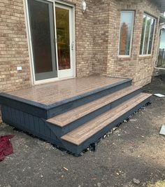 a wooden deck in front of a brick building