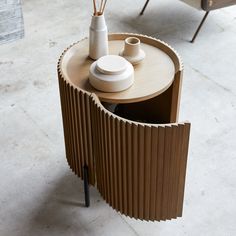 a wooden table with two vases on it and a chair in the background,