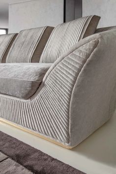 a large couch sitting on top of a white floor next to a window in a living room