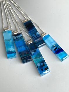 four pieces of blue glass hanging from a silver chain