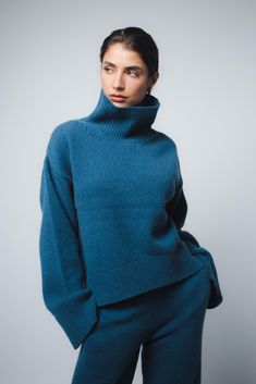 The Cio sweater in Peacock Blue has been knitted in Romania using a luxurious eco-cashmere yarn from a leading Italian mill. Featuring a relaxed fit, dropped shulders and elongated sleeves, wear your hair tucked in the turtleneck and pair with jeans or tailored pieces for an effortless look. Fit: Bianca, our model is 5.8" or 1.77 m tall and wears size 1. Made from a medium-weight knit, the sweater measures approximately 21" (53 cm) at front and 24"(60 cm) at back from shoulder to hem. Content: 1 Elegant Blue Cashmere Sweater, Blue Fitted Cashmere Sweater, Luxury Blue Wool Sweater, Teal Cashmere Sweater, Blue V-neck Cashmere Sweater, Hair Tuck, Oversized Turtleneck, Cashmere Yarn, Womens Turtleneck