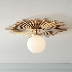 a ceiling light that is hanging from the ceiling in a room with white walls and flooring