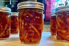 jars filled with pickled vegetables sit on a table