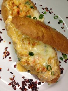 two pieces of bread on a plate with cheese and green pepper sprinkles