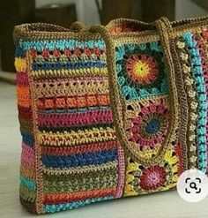 a multicolored crocheted bag sitting on top of a table