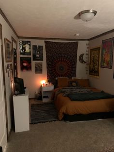 a bed room with a neatly made bed and lots of pictures on the wall above it