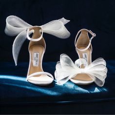 two pairs of white shoes with bows on them