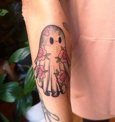 a person with a tattoo on their arm has a bird and flowers tattooed on it