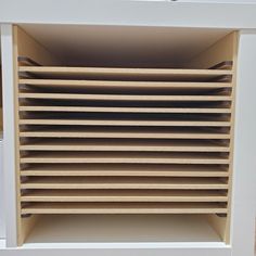 a close up of a white shelf with many shelves on top of it and the bottom part of the shelf is made out of plywood