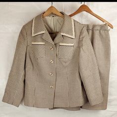 This piece is in good condition commensurate with age and long-term storage. It is structurally sound and both pieces are fully lined. The blazer features original buttons, two breast pockets, and two hip pockets. The skirt features hanger straps, button / zip closure, and front / back pleats. See photos for details. The suit is tagged as a size 44, but Vintage sizes can run very small. Check measurements below before purchasing. *bust, waist and hip measurements taken flat and doubled* ~ Blazer Workwear Sets With Buttons And Lapel Collar, Workwear Sets With Lapel Collar And Buttons, Classic Notch Lapel Skirt Suit With Buttons, Classic Skirt Suit With Notch Lapel, Classic Tailored Skirt Suit With Button Closure, Classic Tailored Skirt Suit, Tailored Semi-formal Skirt Suit With Buttons, Tailored Semi-formal Skirt Suit, Classic Skirt Suit With Button Closure For Office