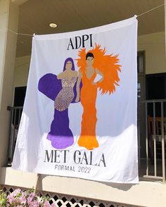 a banner hanging from the side of a building with two women dressed in different outfits