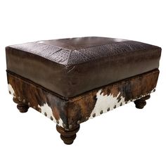 a brown and white ottoman sitting on top of a wooden table