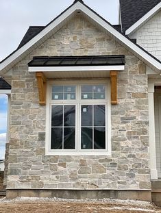 a stone house with white trim and windows