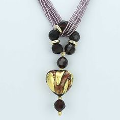 This gorgeous contemporary Murano necklace in rich amethyst and gold color palette features an exquisite 24K gold-layered heart at the center attached to a beautiful beaded ring and suspended from an elegant multi-strand beaded necklace. When this Venetian necklace captures the light you can really see it shine, as the seed beads and the heart light up with rich shades of amethyst, violet, and lilac reminding us of the treasures kept in Venice's decadent palazzos. This Murano glass necklace is a Glass Pendant Necklace For Formal Occasions, Glass Pendant Necklaces For Formal Events, Elegant Single Strand Heart Necklace, Elegant Glass Beaded Jewelry, Elegant Beaded Glass Jewelry, Elegant Handmade Necklace With Czech Glass, Elegant Czech Glass Necklaces With Round Beads, Handmade Elegant Necklace With Czech Glass, Elegant Handmade Necklaces With Czech Glass