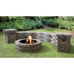 an outdoor fire pit sitting on top of a lush green field