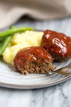 meatloaf with mashed potatoes and green beans on a plate