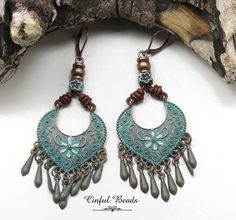 "This pair of boho earrings features rustic antique copper plated pendants with a turquoise (verdigris) patina. The pendants are decorated with brown leather barrel knots and a square floral bead with a patina finish. The leather has been glued into antique copper cord ends. The earwires are nickel free and lead free lever backs. The earrings measure 3 1/4\" long and 1 1/4\" wide. All jewelry is packaged ready for gift giving as shown in the last photo. Each item comes in an organza bag with a c